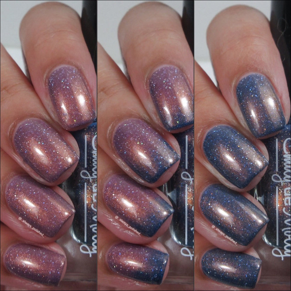 Close-up of a hand with glittery purple and blue nail polish on a white background.