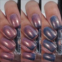 Close-up of a hand with glittery purple and blue nail polish on a white background.